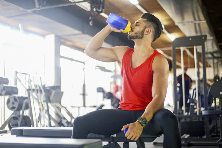 Man drinking protein drink at the gym