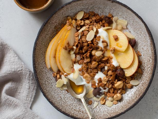 Muesli, apples, pears and yogurt in rustic plate. Healthy breakfast concept. Flat lay. Copy space