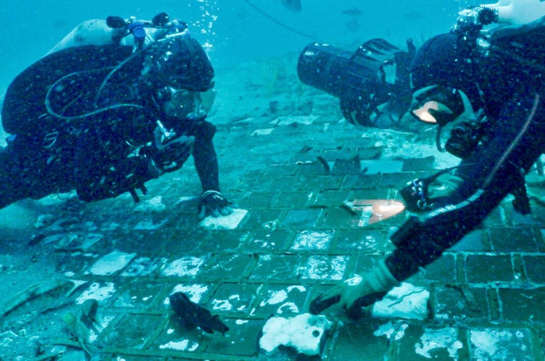 Underwater explorer and marine biologist Mike Barnette and wreck diver Jimmy Gadomski explore a segment of NASA