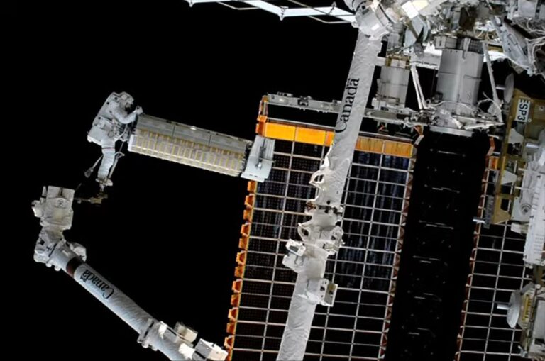 NASA astronauts on station spacewalk deploy roll-out solar array