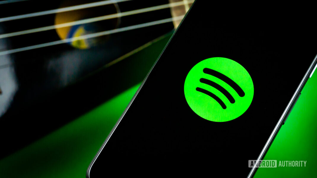 Spotify on a phone next to a guitar