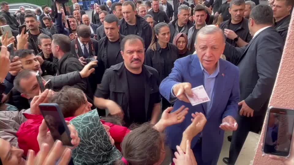 Erdogan hands cash to supporters at polling station