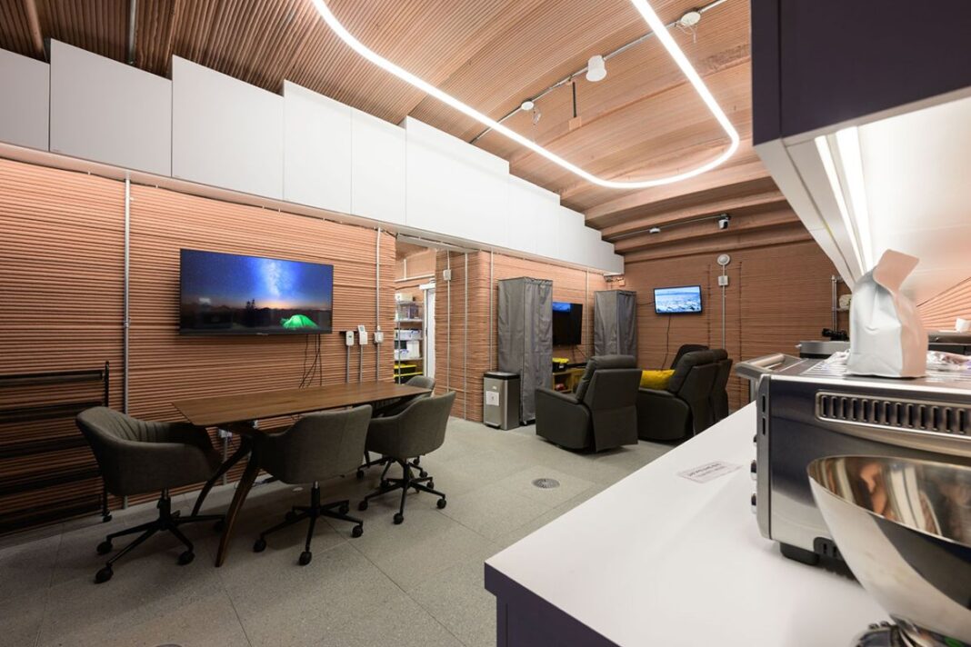 interior of a nasa mock mars base with meeting space, kitchen and futuristic lighting