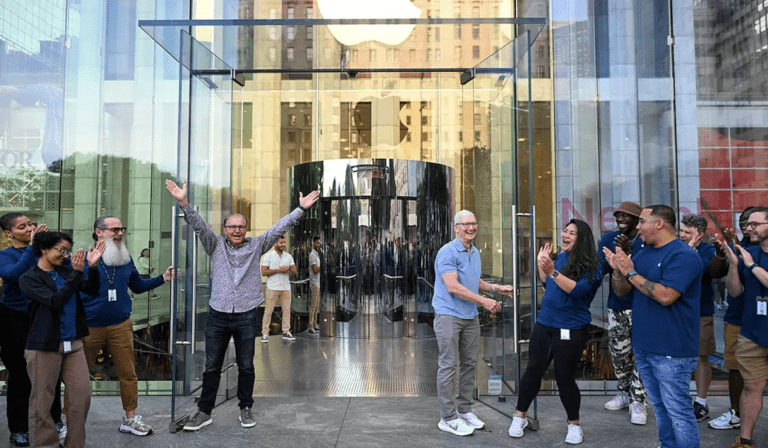 Greg Joswiak and Tim Cook welcome iPhone 15 buyers in Fifth Avenue store